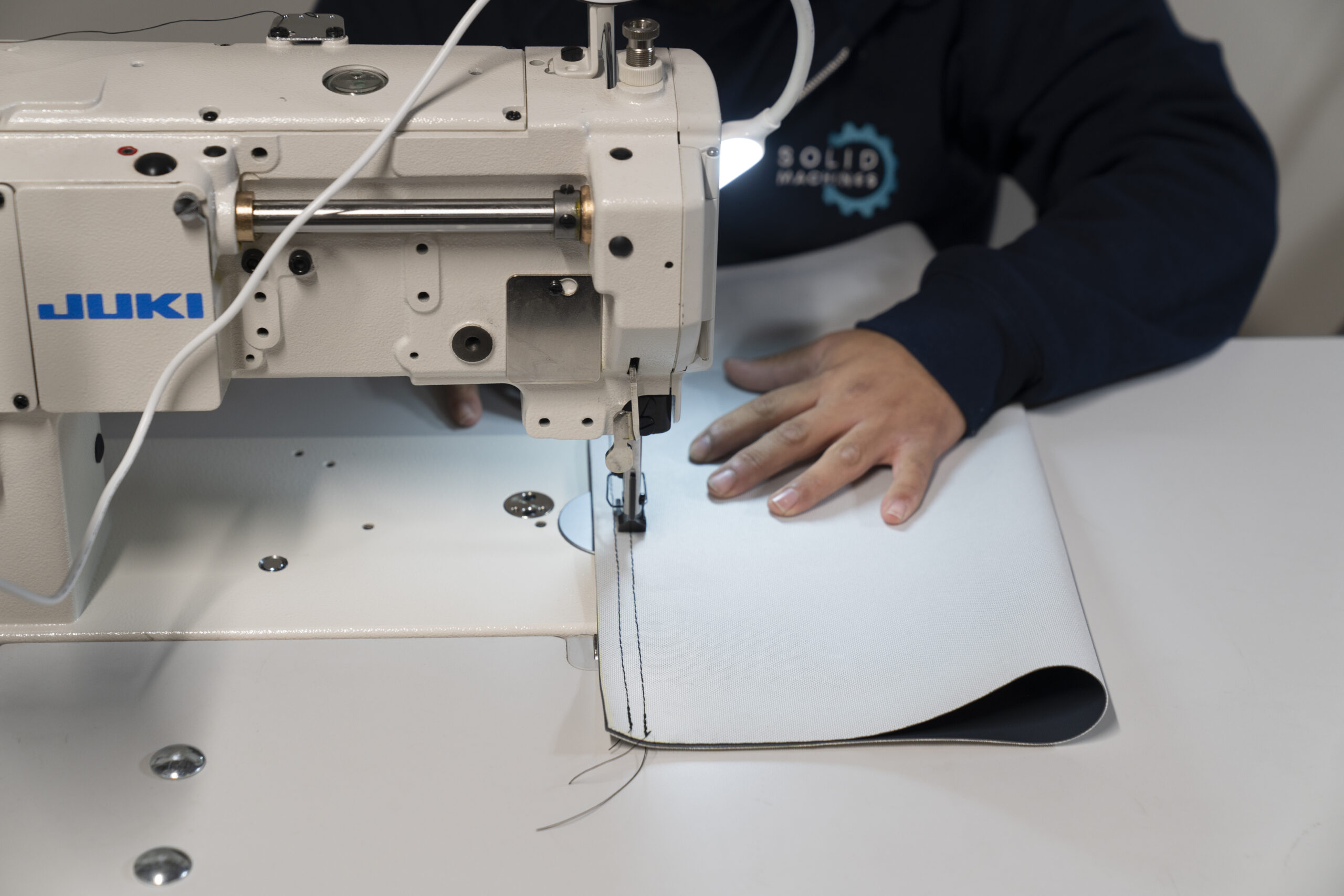 Off-site sewing of fitness equipment vinyl at the Solid Machines shop